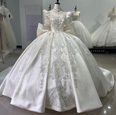 a dress on display in a room with mannequins and other wedding gowns