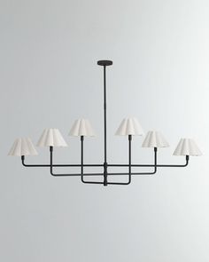 a black chandelier with six white lamps hanging from it's center point