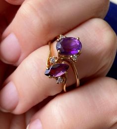 Please note that this listing is for 1 ring only... the TOP ring in the photo. The marquis ring has SOLD, the photo is showing how the ring looks on the finger. Loving those juicy rich purple tones lately. Sweet vintage amethyst gold ring. Circa 1970s - 1980s or so.  Signed 10K Magic Glo inside the shank. Central oval stone tests as amethyst on my gem tester, it's faceted and oval in shape. Measures approx 8 x 5 mm. Set at a slight angle or diagonal. Two little sparkly white stones to either side of the amethyst. I didn't get a diamond reading on these but they're very small and hard to test. Could possibly be white topaz or something similar. Ring sits up approx 7 mm total height.  10K yellow gold. Weighs 1.92 grams. Size 6.75 US resizable.  In very good used vintage condition. For 1 ring Marquis Ring, Amethyst Ring Vintage, 10k Gold Ring, Purple Tones, Marquise Ring, White Stones, Amethyst Gold, Top Rings, Rich Purple