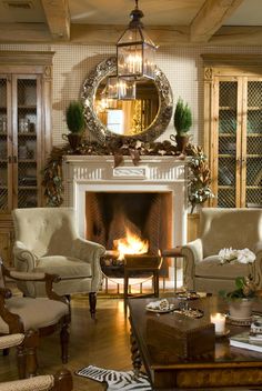 a living room filled with furniture and a fire place under a mirror on the wall