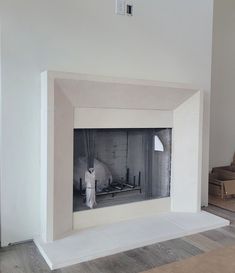 an empty room with a white fireplace and boxes on the floor