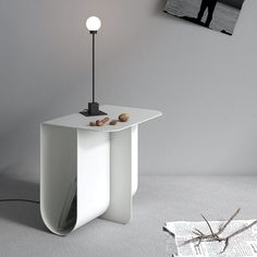 a white table with a lamp on it next to a newspaper