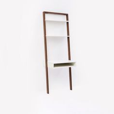 a white shelf sitting on the side of a wall next to a brown bookcase