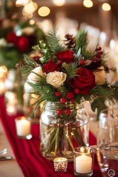 a vase filled with flowers and greenery on top of a red table cloth next to candles