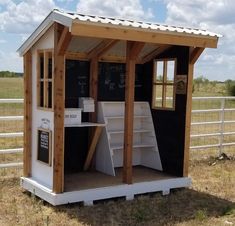 a small white shed sitting on top of a dry grass field