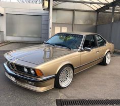 a gold car parked in front of a building