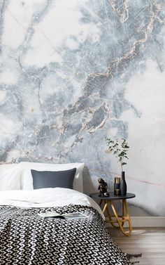 a bedroom with marble wallpaper and white bedding, along with two side tables