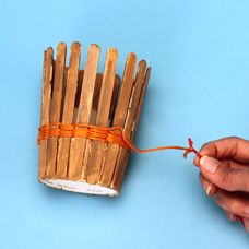 a person holding a bundle of sticks in their hand and tied with string on the end