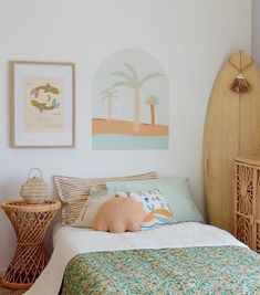 a bedroom with a bed, wicker baskets and pictures on the wall above it