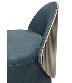 the back of a blue velvet chair with gold trimmings and an oval shaped foot rest