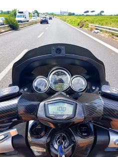 a motorcycle is driving down the road with other vehicles behind it