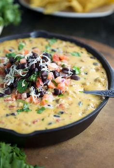 a skillet filled with black beans, cheese and tortilla chips