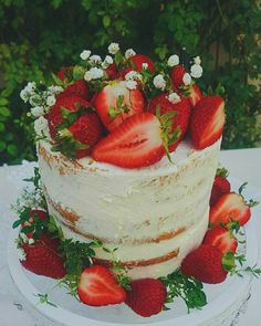 a white cake with strawberries and flowers on top