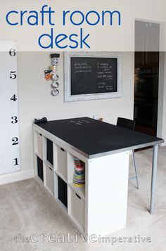 a black and white kitchen island with chalkboard on the wall behind it in a room