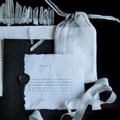 an assortment of items are displayed on a black tablecloth with white ribbons and tags