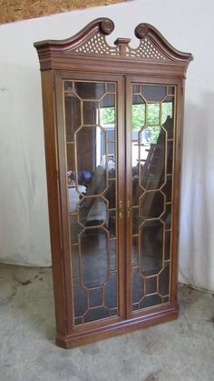 an ornate wooden armoire with glass doors