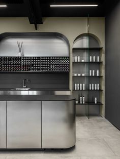 an empty kitchen with stainless steel appliances and shelves in the back ground, surrounded by glass doors