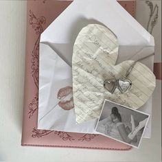 an open envelope with a heart and two photos attached to it