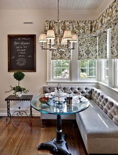 a breakfast nook in the corner of a room with a chalkboard on the wall