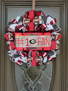 a football wreath with the number one fan on it is hanging on a front door