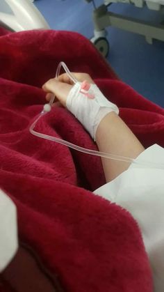 a person in a hospital bed with an iv hooked up to their arm and hand