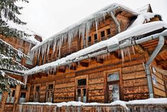 an old wooden house with icicles hanging from the roof