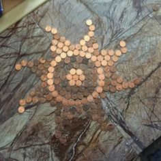 some coins sitting on top of a table with a person standing next to it in the background