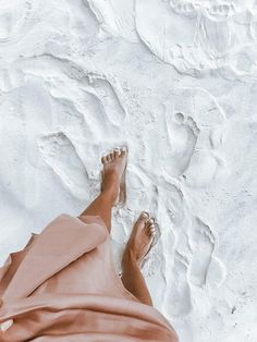 a person laying in the sand with their feet up