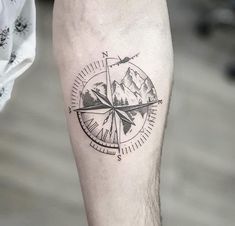 a man with a compass tattoo on his leg