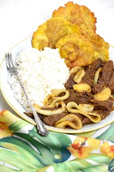 a white plate topped with rice and meat next to other food on top of a table