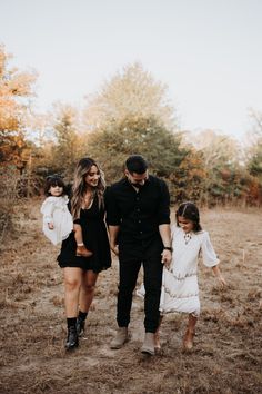 a family walking through the woods holding hands