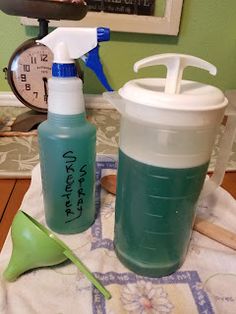 two plastic containers sitting on top of a table next to a green measuring cup and spoon