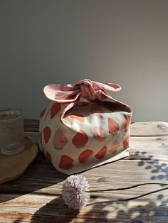 a polka dot bag sitting on top of a wooden table next to a straw hat