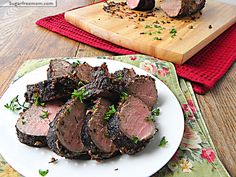 slices of roast beef on a white plate with parsley sprinkled around the edges