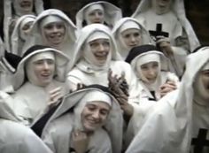 a group of women dressed in white are smiling and posing for the camera with their hands together