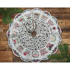 a white doily with red and green designs on it sitting on top of a wooden table