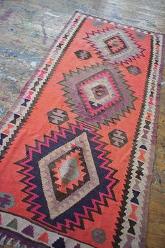 an old rug is laying on the floor with it's colorful colors and patterns