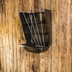 a bird cage hanging on the side of a wooden fence