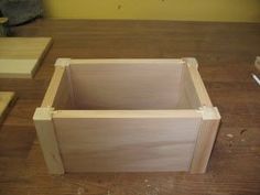 a wooden box sitting on top of a table next to a pair of scissors and some wood