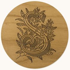 a wooden coaster with an image of the letter s in floral designs on it's surface