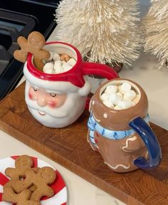 two mugs filled with hot chocolate and marshmallows on a wooden tray