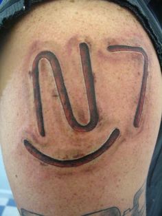 a man's arm with a smiley face drawn on it and the word love spelled in cursive writing