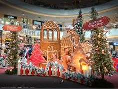 a christmas display in the middle of a mall with decorations on each side and large gingerbread houses