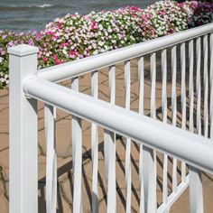 a white metal railing with flowers in the background