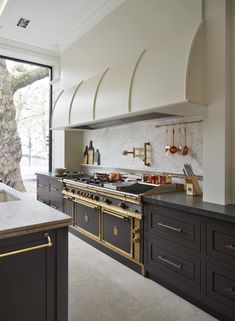 a kitchen with an oven, stove and counter top next to a large glass window