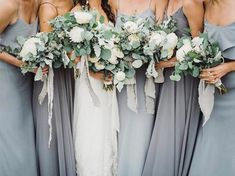 the bridesmaids are holding their bouquets with white flowers and greenery on them