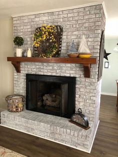 a white brick fireplace in a living room with wood flooring and decor on the mantle