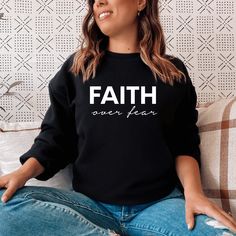 Keep warm and comfortable in this Faith Over Fear Sweatshirt. This cool Christian sweatshirt is soft, stylish, and sure to keep you warm in the colder months. It's versatile to wear for a day outdoors, heading to the gym, or a lazy day watching movies on the couch. Wearing Christian hoodies and sweatshirts can be a subtle way to express your faith and create conversations with anyone and be a gentle reminder to encourage you in any season. They can also spread encouraging words of faith everywhe Comfy Black Sweatshirt For Loungewear, Black Relaxed Fit Comfortable Sweater, Black Comfortable Relaxed Fit Sweater, Black Winter Sweats, Comfortable Black Winter Sweats, Casual Black Sweatshirt With Cozy Fit, Black Comfy Sweatshirt With Relaxed Fit, Black Relaxed Fit Comfy Sweatshirt, Comfy Black Sweats For Winter