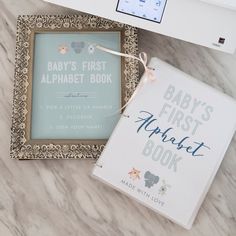 a baby's first book next to an open laptop computer on a marble surface