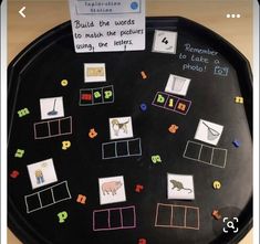 a black tray with pictures and words on it that are written in different colors, shapes and sizes